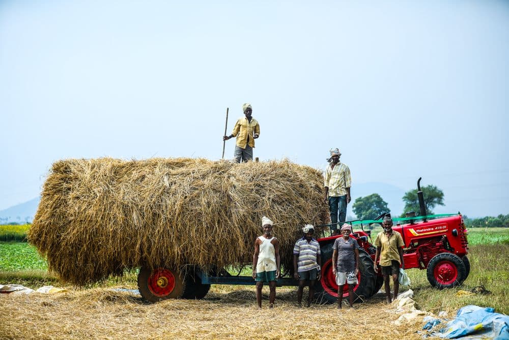 भूसे से लदी ट्रॉली के साथ किसानों का समूह